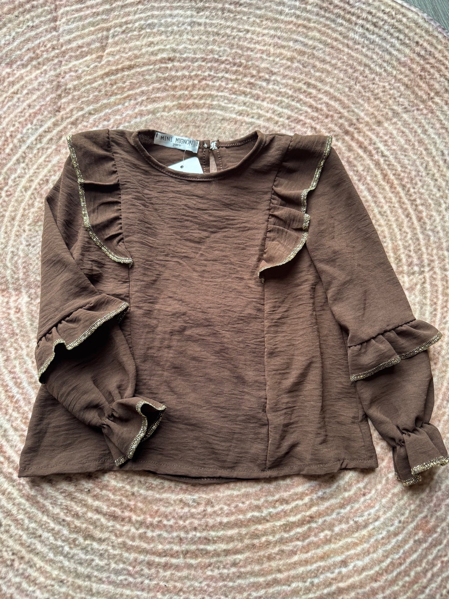 Top met ruches en gouden bies.